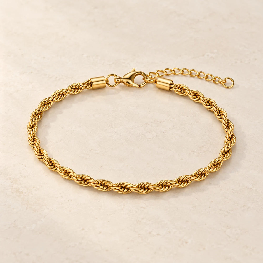 Gold-tone 3 mm rope chain bracelet on a pale limestone background