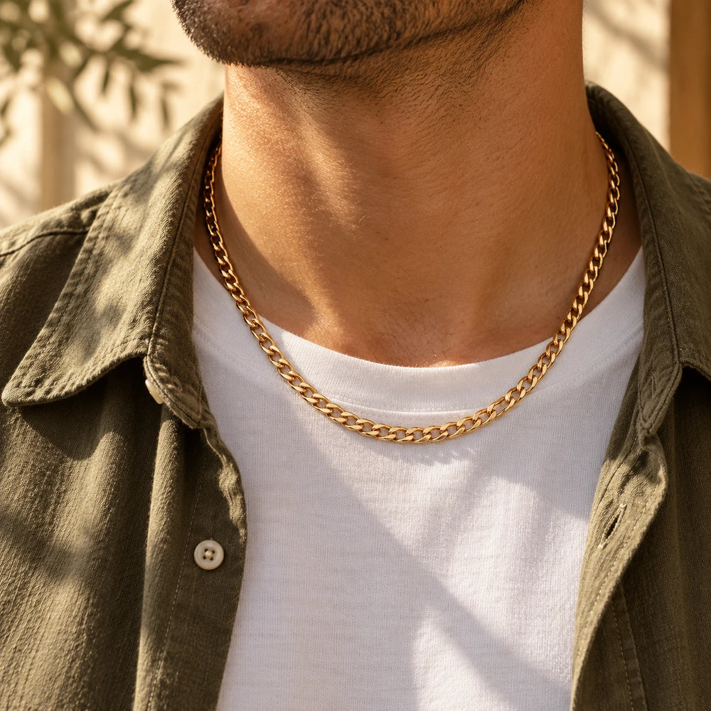 Gold-tone 4 mm flat curb chain necklace worn over a white t-shirt and olive overshirt — true size: the flat curb chain is 4 mm wide with 1 mm wire