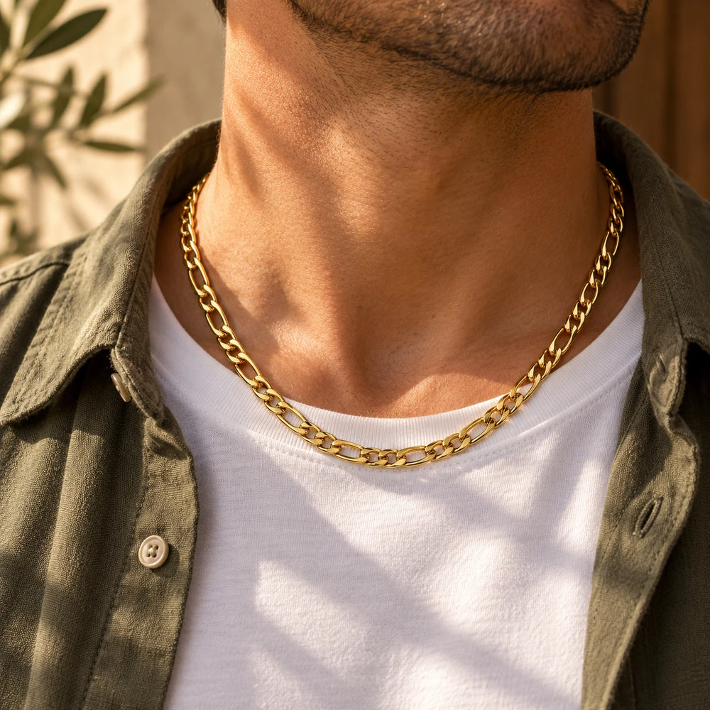 Gold-tone 5 mm figaro chain necklace worn over a white t-shirt and olive overshirt — true size: the figaro chain is 5 mm wide with about 1.4 mm wire