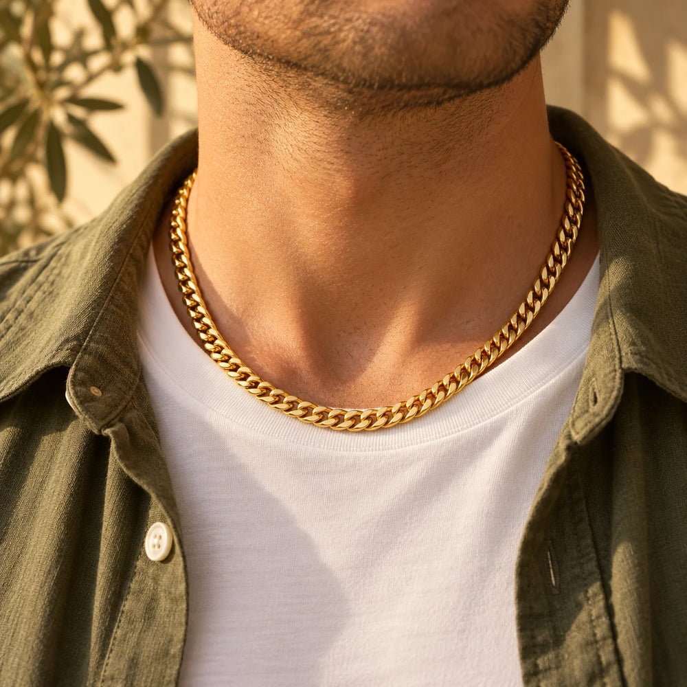 Gold-tone 6 mm cuban chain necklace worn over a white t-shirt and olive overshirt — true size: the dense cuban chain is 6 mm wide