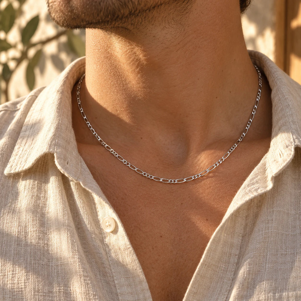Silver-tone 3 mm figaro chain necklace worn at the collarbone with an open linen shirt — true size: the figaro chain is 3 mm wide with 0.8 mm wire