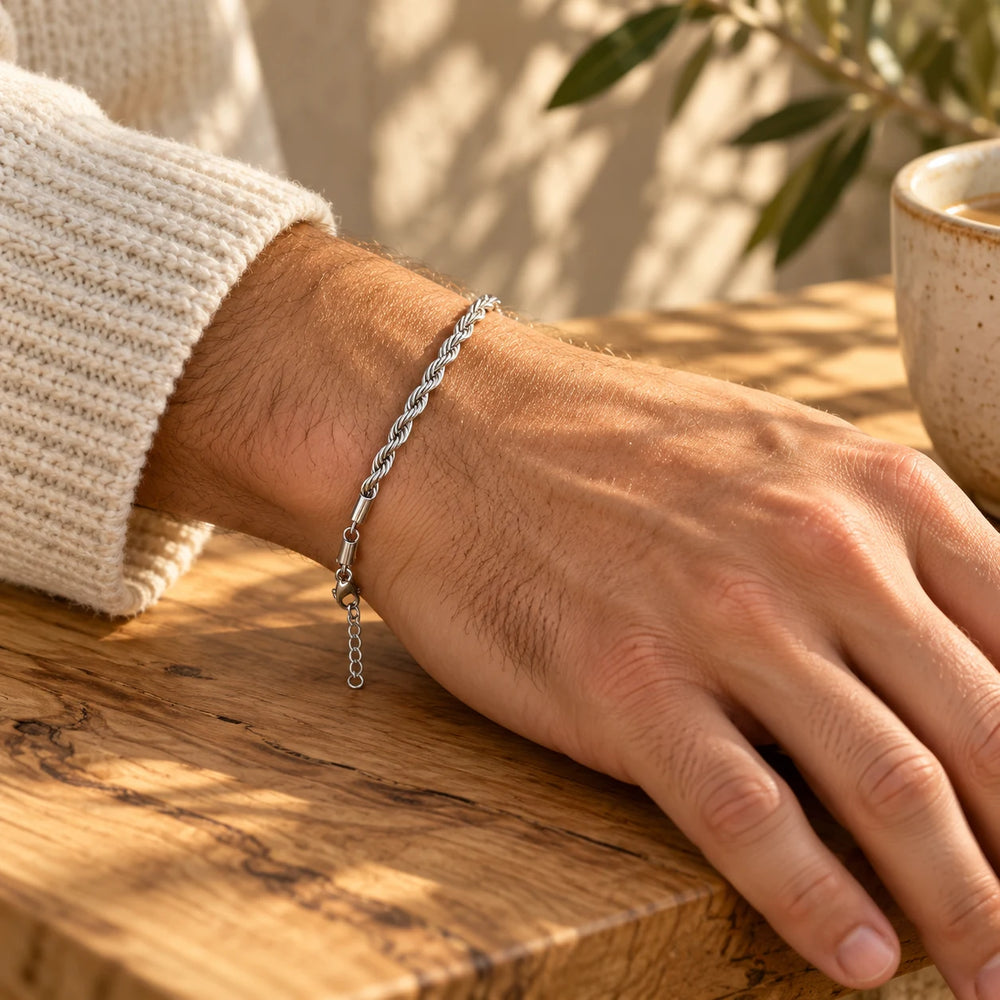 Silver-tone 3 mm rope chain bracelet on a man's wrist on an olive-wood table — true size: the twisted rope bracelet is 3 mm thick, 17 cm + 5 cm extender