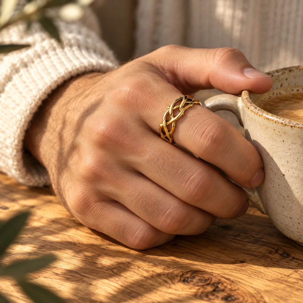 Gold-tone crown of thorns ring worn on a man's hand