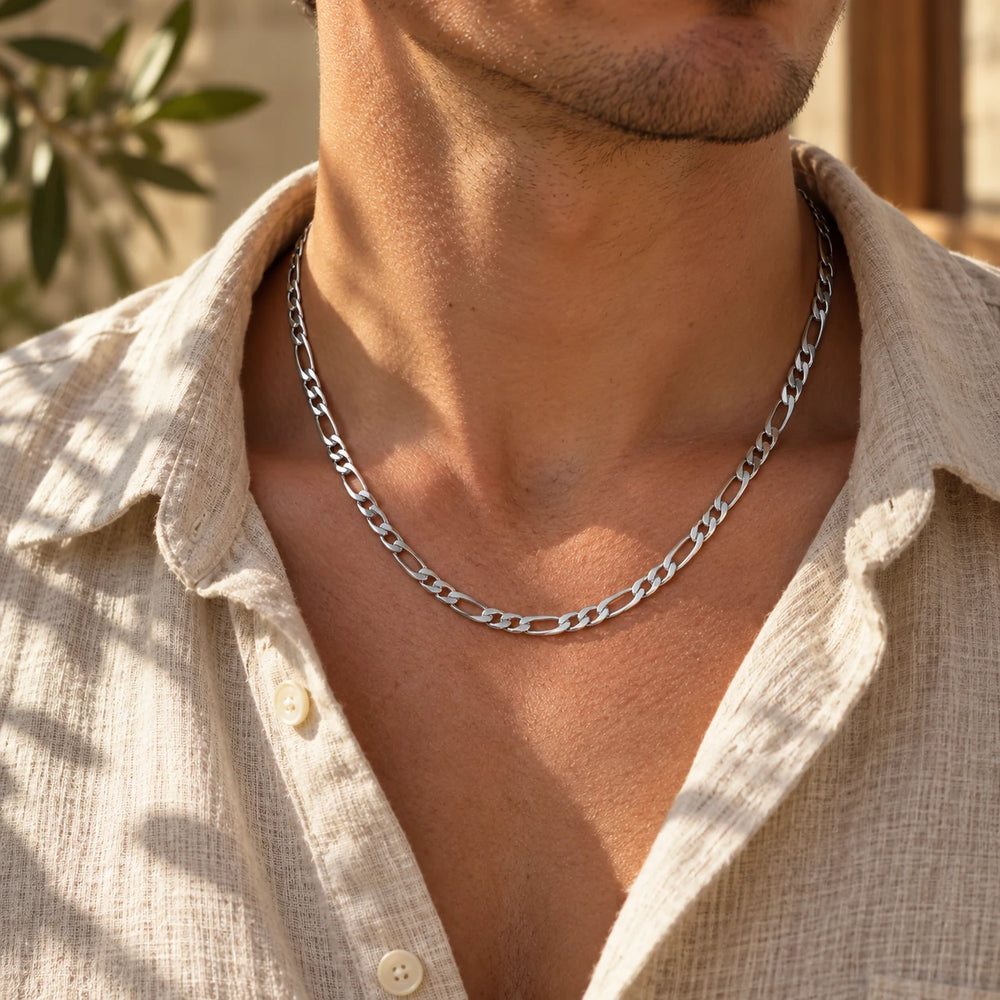 Silver-tone 5 mm figaro chain necklace worn at the collarbone with an open linen shirt — true size: the figaro chain is 5 mm wide with about 1.4 mm wire