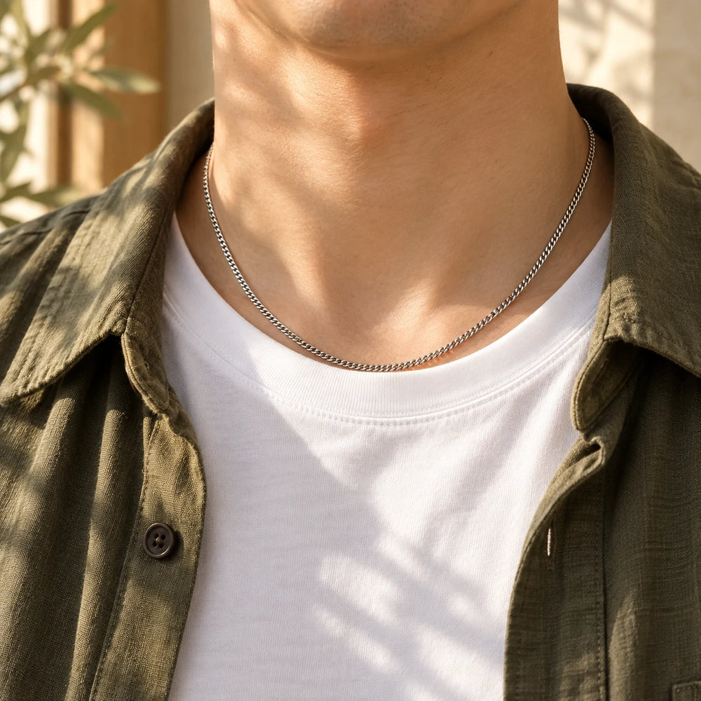 Silver-tone 2 mm cuban chain worn by a man over a white t-shirt — true size: the curb chain is 2 mm wide
